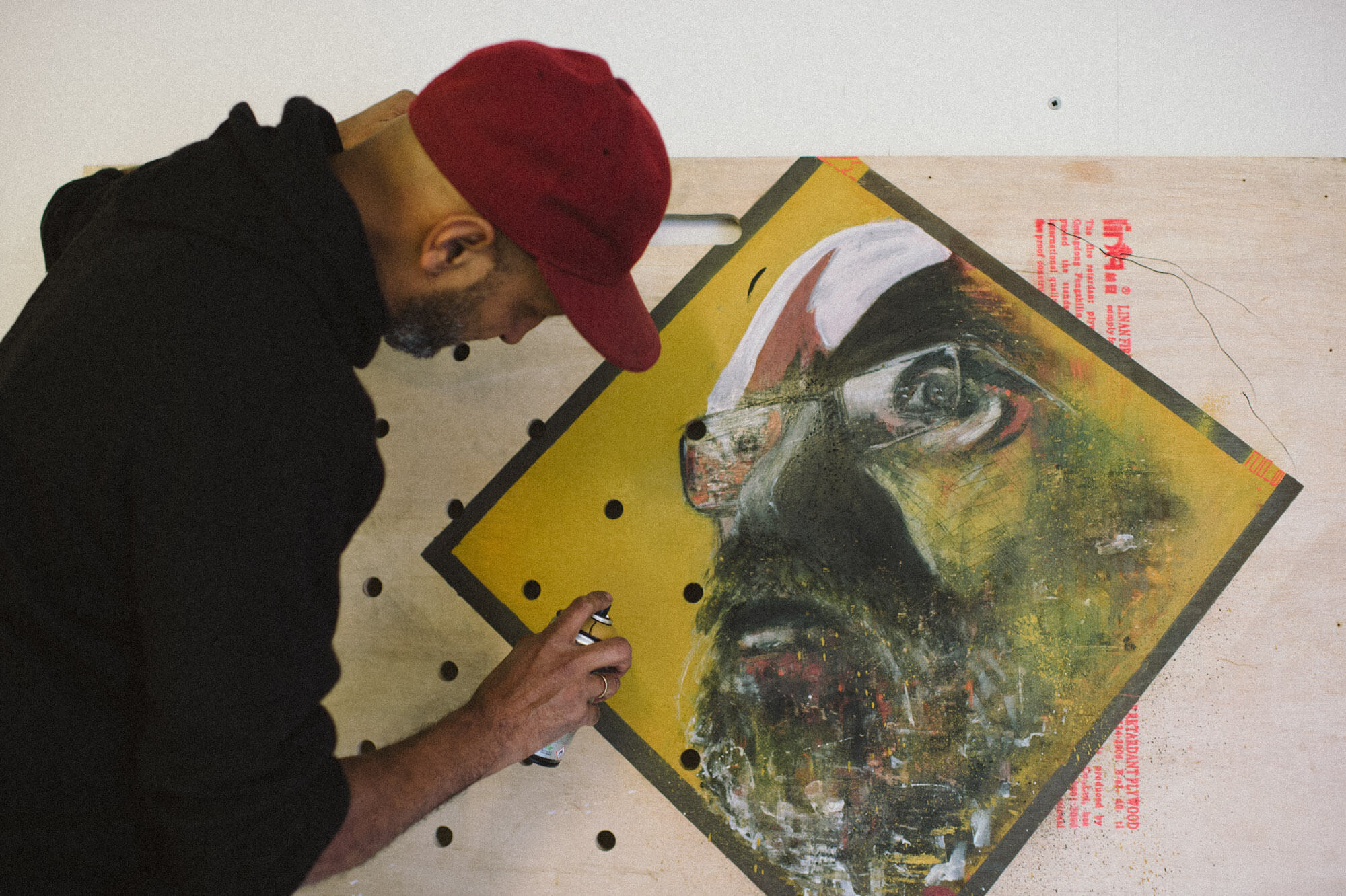 NIMI spraying on some yellow work with a face on