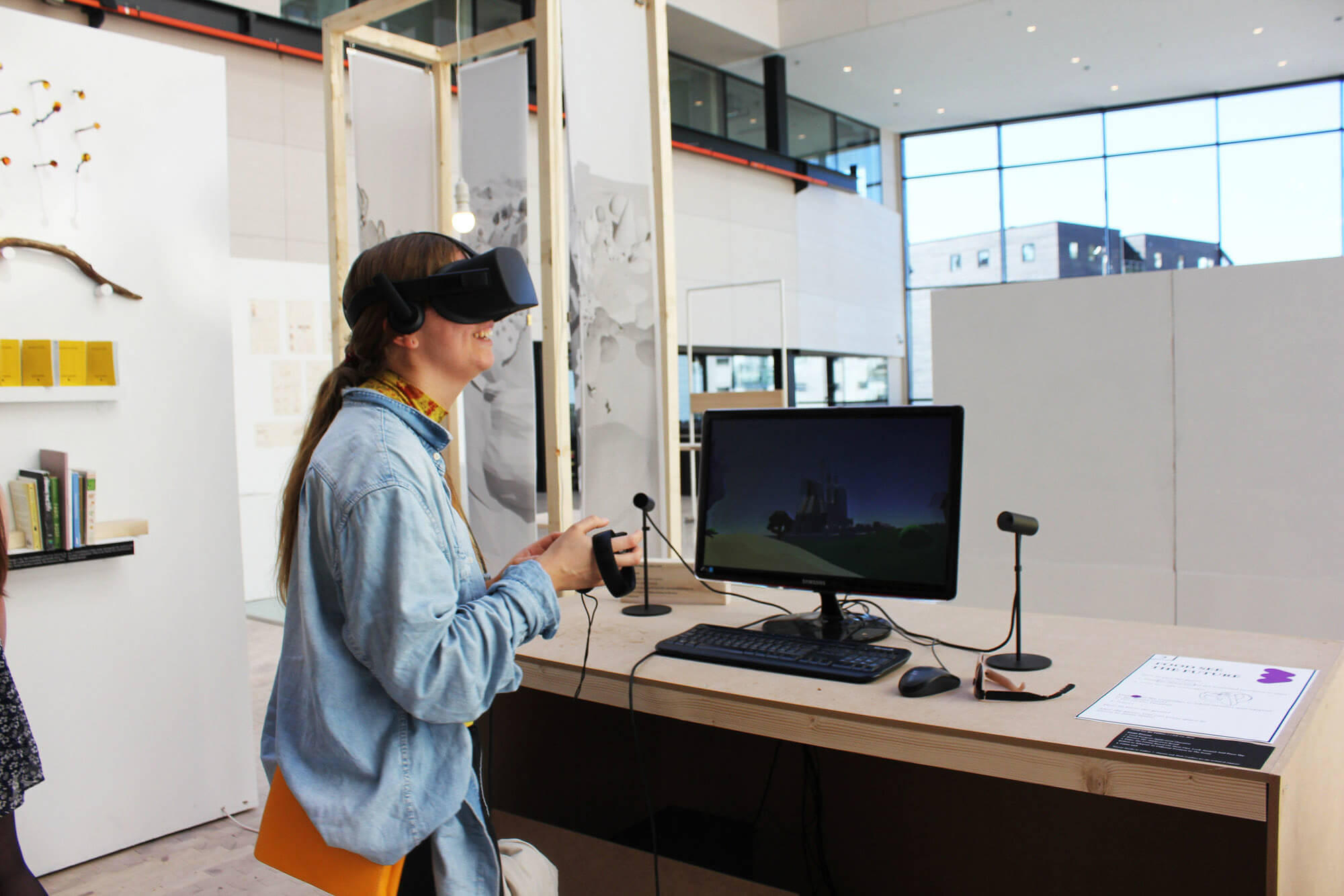 A young woman using VR equipment to discover a 3D world on a screen
